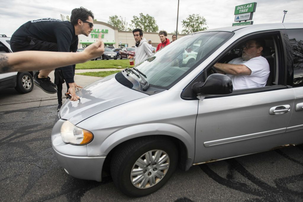 Third Place, General News - Rebecca Benson / The Blade, “Road Rage”A protester jumps onto a mans car after almost hitting him with his car on South Reynolds Road in Toledo on June 1, 2020. The driver accelerated his car into the protester as he was trying to take a photo of his license plate after almost hitting other protesters in the road. 